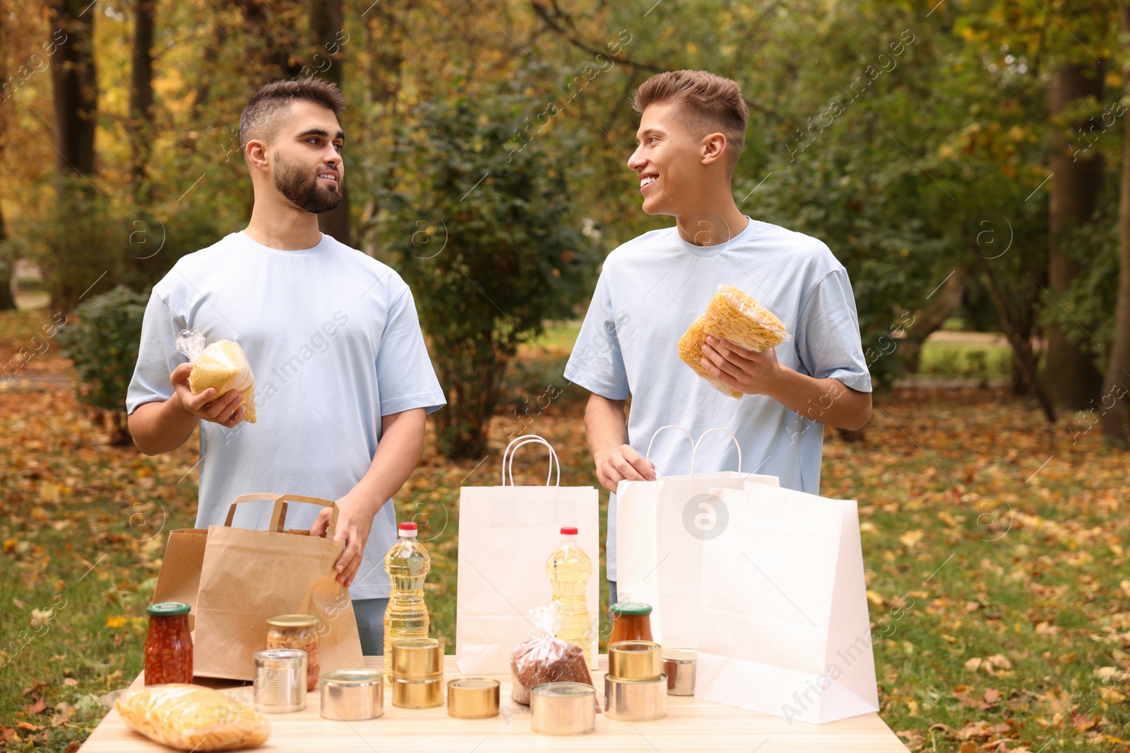 Photo of Volunteers packing food products at table in park