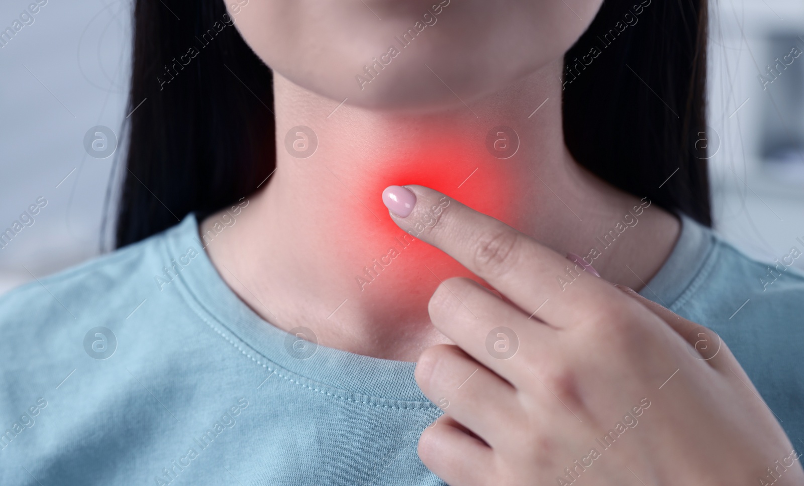 Image of Endocrine system. Woman doing thyroid self examination indoors, closeup