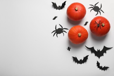 Flat lay composition with pumpkins, paper bats and spiders on white background, space for text. Halloween celebration