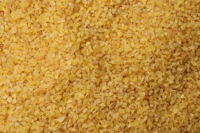 Pile of raw bulgur as background, top view