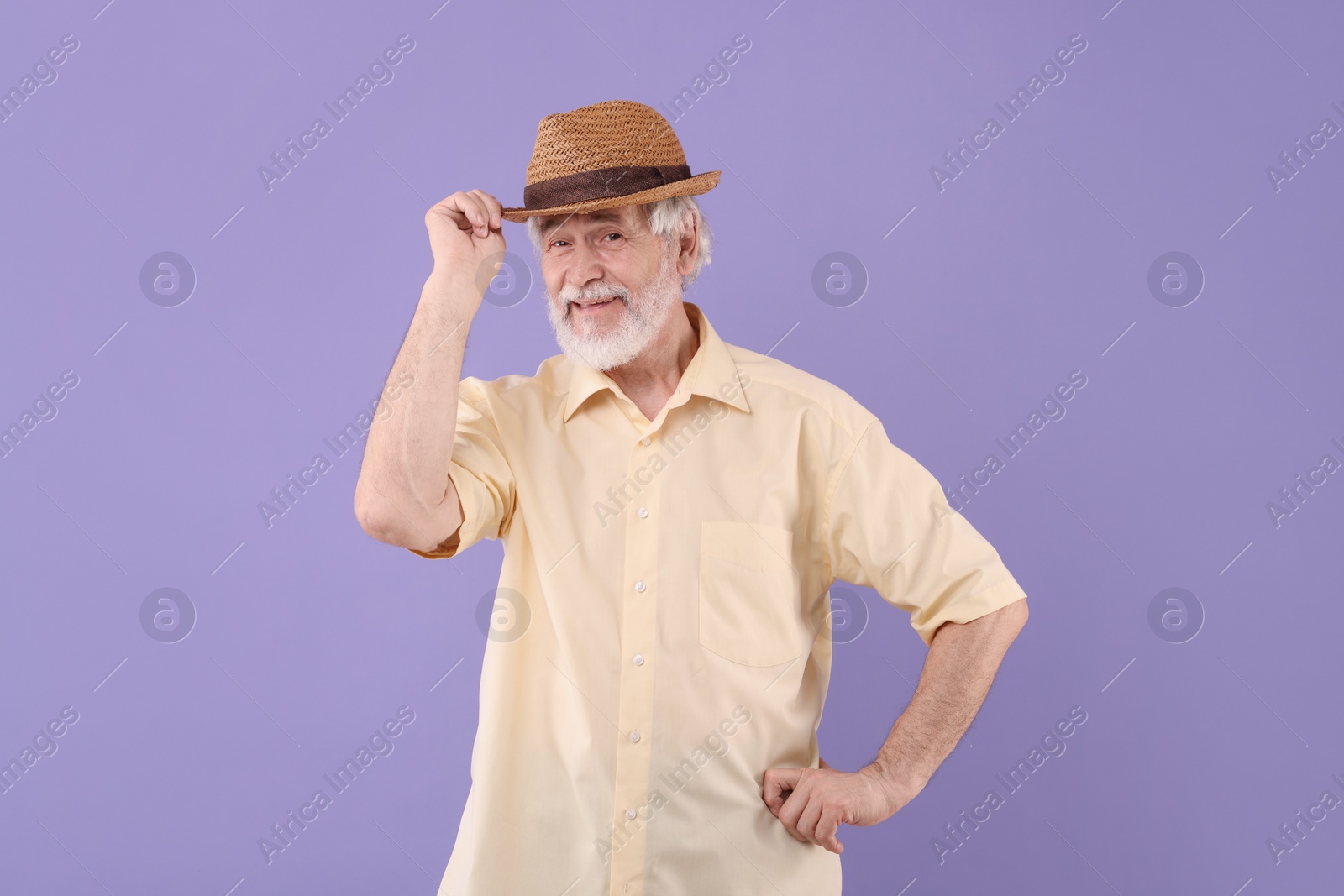 Photo of Portrait of stylish grandpa with hat on purple background