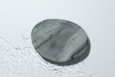 Photo of Presentation for product. Stone podium in water on white background, top view