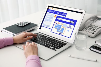 Woman working with modern laptop at white table indoors, closeup. Job search