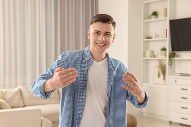 Handsome man inviting to come in room at home