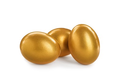 Photo of Many shiny golden eggs on white background