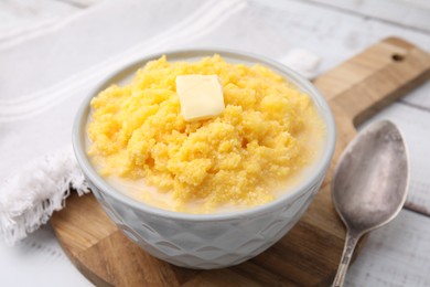 Photo of Tasty cornmeal with butter in bowl served on table, closeup