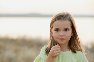 Cute little girl outdoors on sunny day. Child spending time in nature