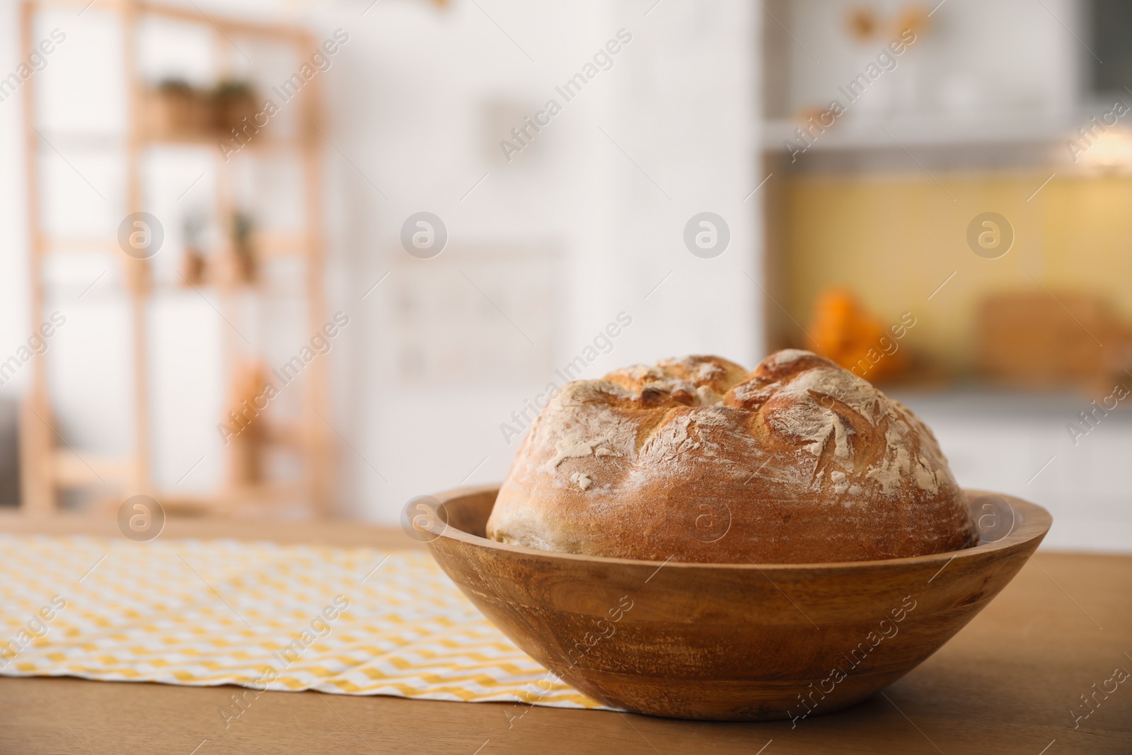 Photo of Bowl with fresh bread on table in kitchen