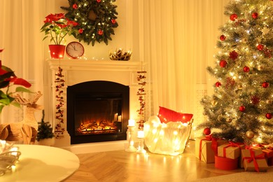 Beautiful living room interior with burning fireplace and Christmas tree in evening