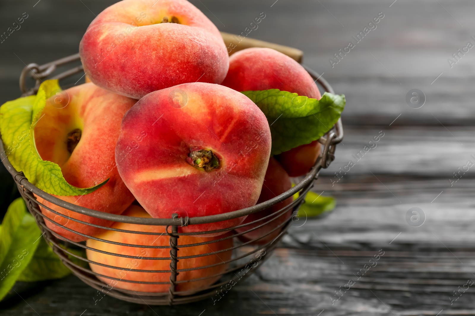 Photo of Fresh ripe donut peaches on black wooden table, closeup