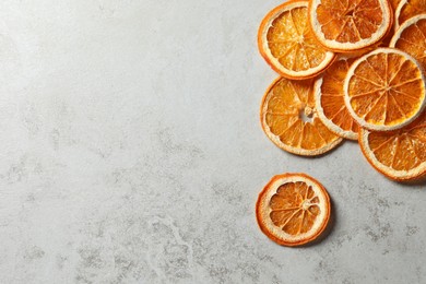 Dry orange slices on light grey table, flat lay. Space for text