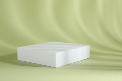 Photo of Presentation of product. Podium and shadows on light green background. Space for text