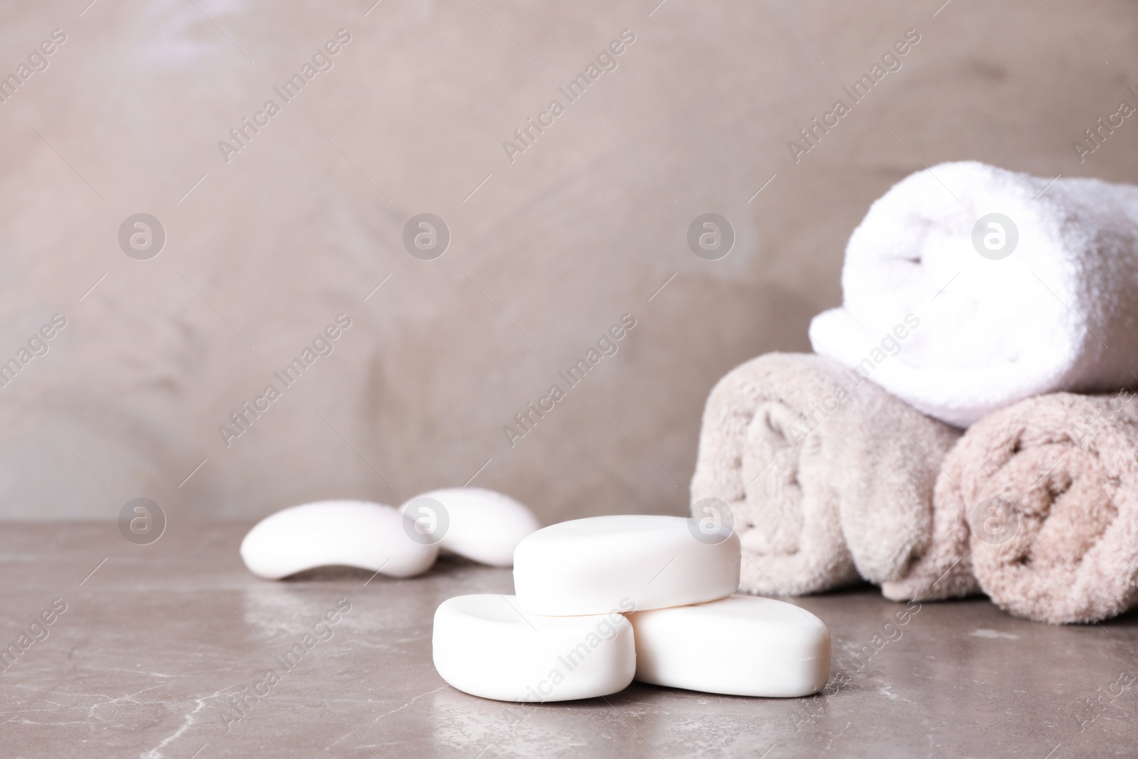 Photo of Soap bars and towels on color table. Space for text
