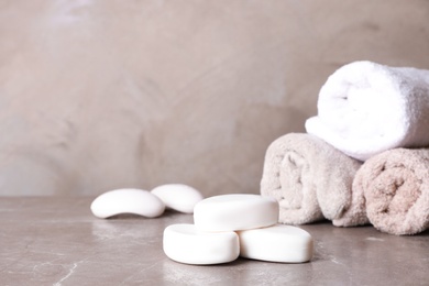 Photo of Soap bars and towels on color table. Space for text