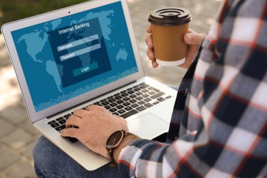 Image of Man using online banking application on laptop outdoors, closeup