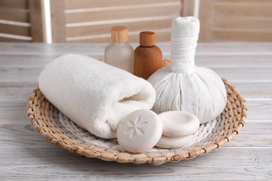 Photo of Spa composition with skin care products and wicker basket on white wooden table