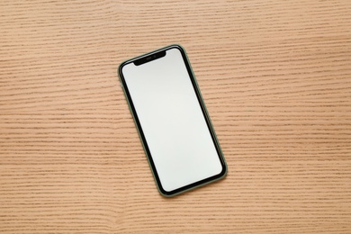 Photo of MYKOLAIV, UKRAINE - JULY 07, 2020: iPhone 11 on wooden background, top view. Mockup for design