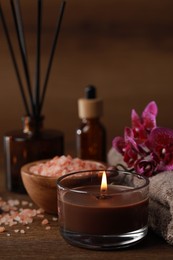 Beautiful spa composition with burning candle, sea salt and flowers on wooden table