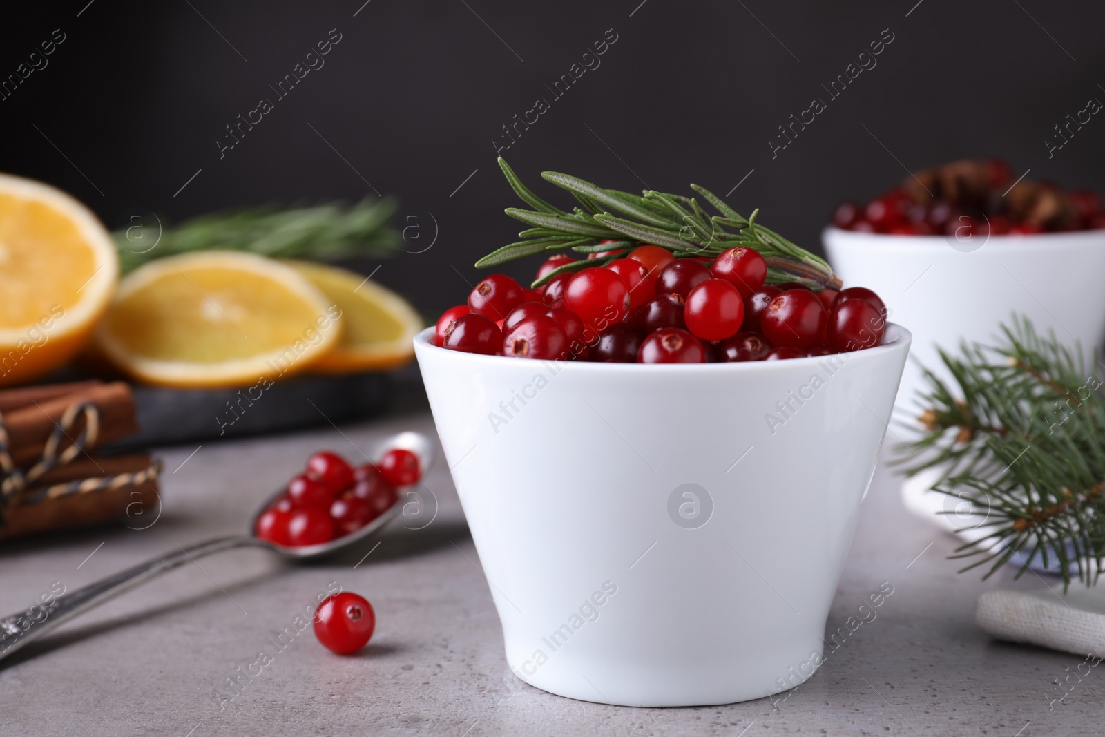 Photo of Fresh ripe cranberries and spices on grey table. Space for text