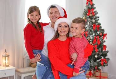 Photo of Happy parents celebrating Christmas with children at home