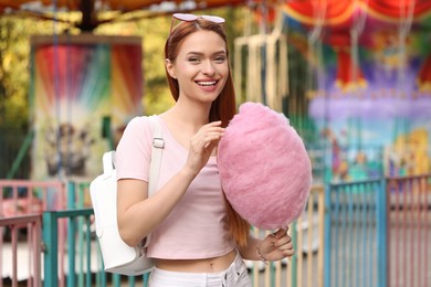 Photo of Smiling woman with cotton candy at funfair