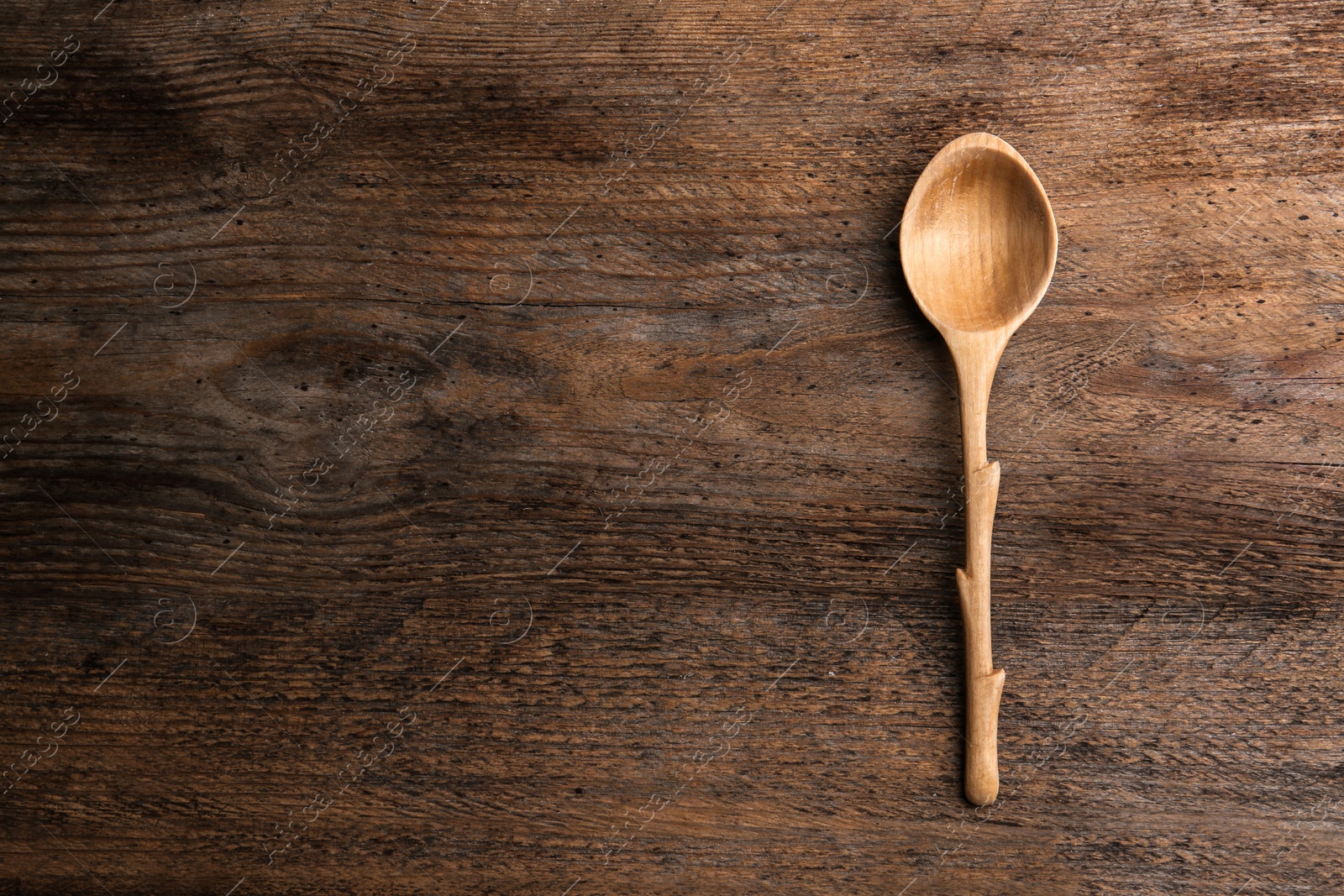 Photo of Clean empty spoon on wooden background, top view. Space for text