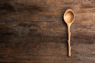 Photo of Clean empty spoon on wooden background, top view. Space for text