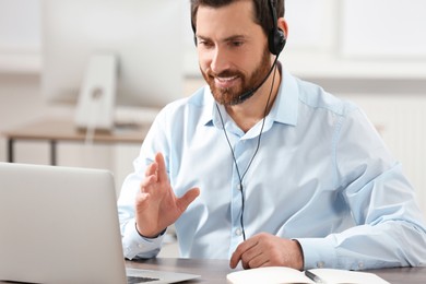 Photo of Hotline operator with headset working in office