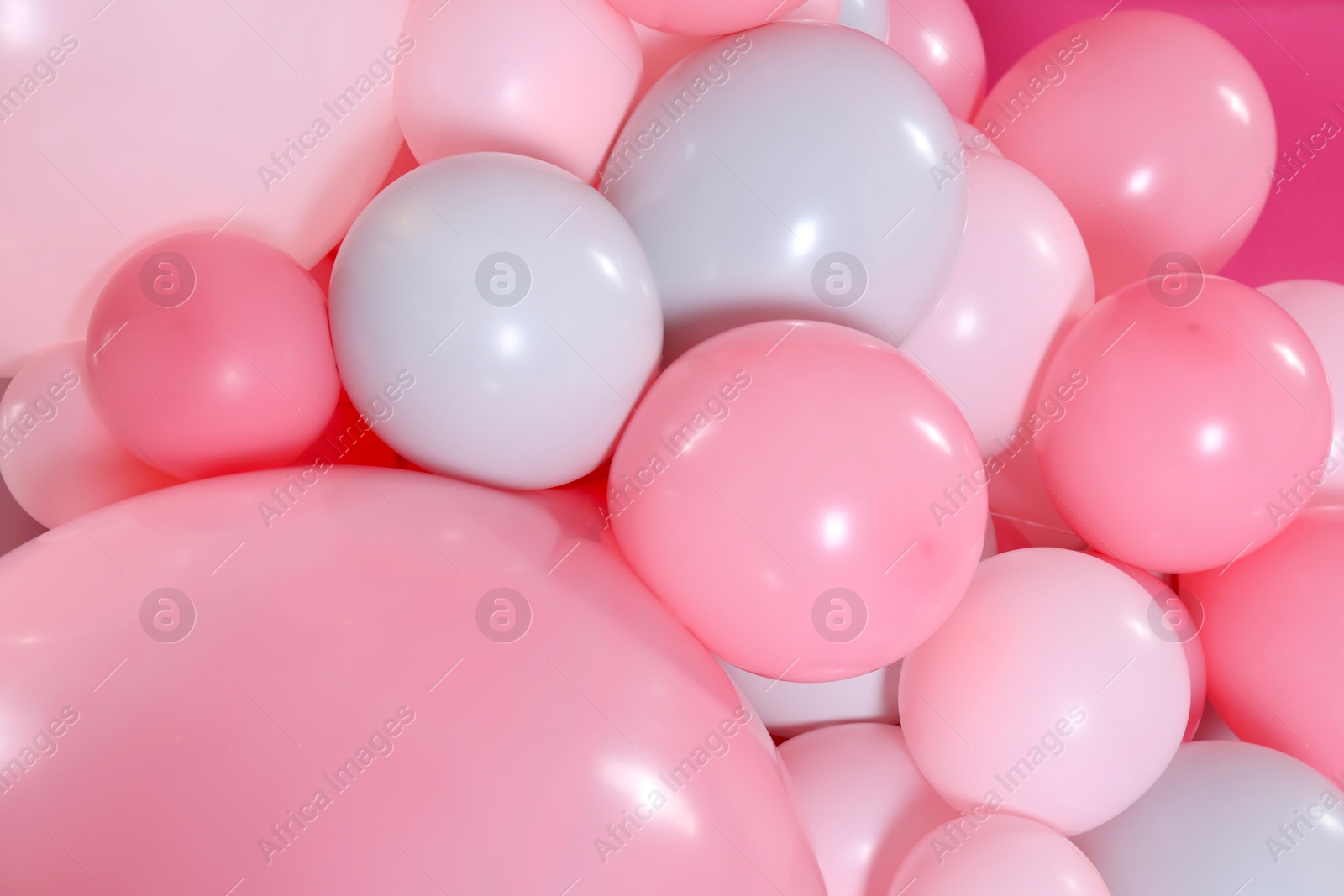 Photo of Beautiful colorful balloons on pink background, closeup