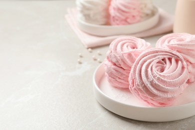 Photo of Delicious pink marshmallows on light grey table. Space for text