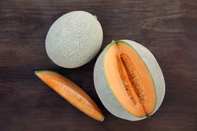 Whole and cut delicious ripe melons on wooden, flat lay