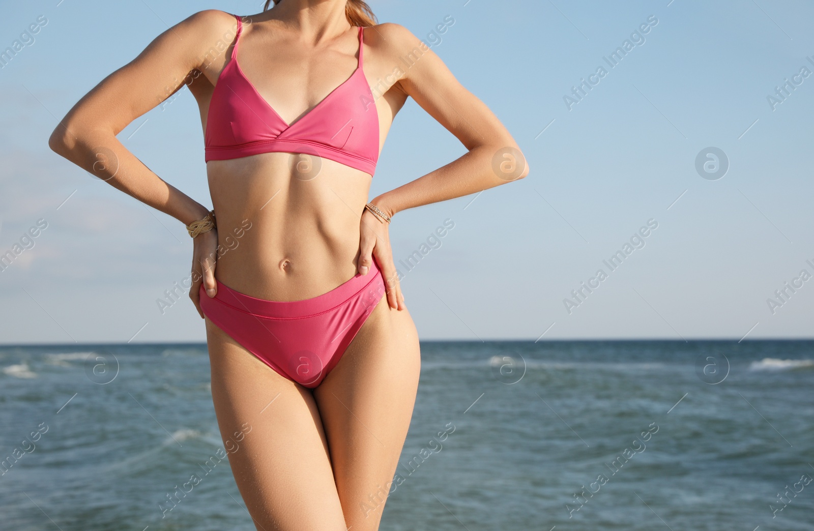 Photo of Woman with beautiful body in bikini near sea, closeup
