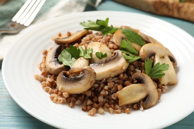 Tasty buckwheat with fresh parsley and mushrooms on table, closeup