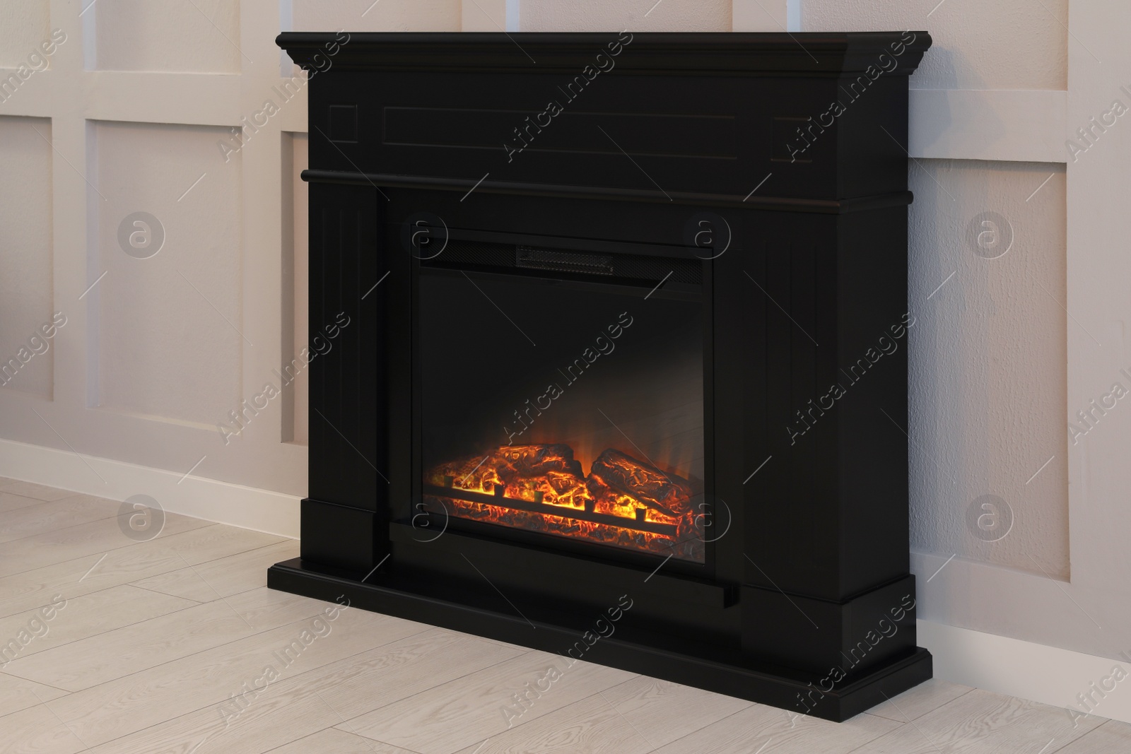 Photo of Modern electric fireplace near light wall indoors