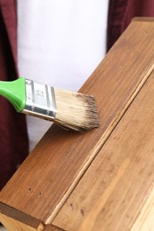 Photo of Applying wood stain onto crate, closeup view