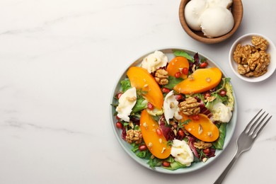 Photo of Delicious persimmon salad with cheese and pomegranate served on white marble table, flat lay. Space for text