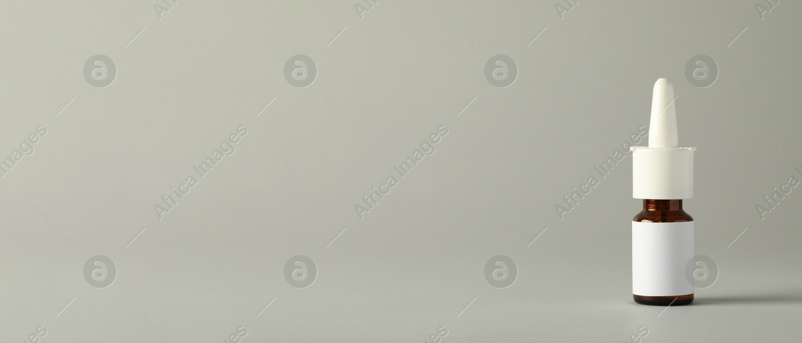 Photo of Bottle of nasal spray on light grey background, space for text
