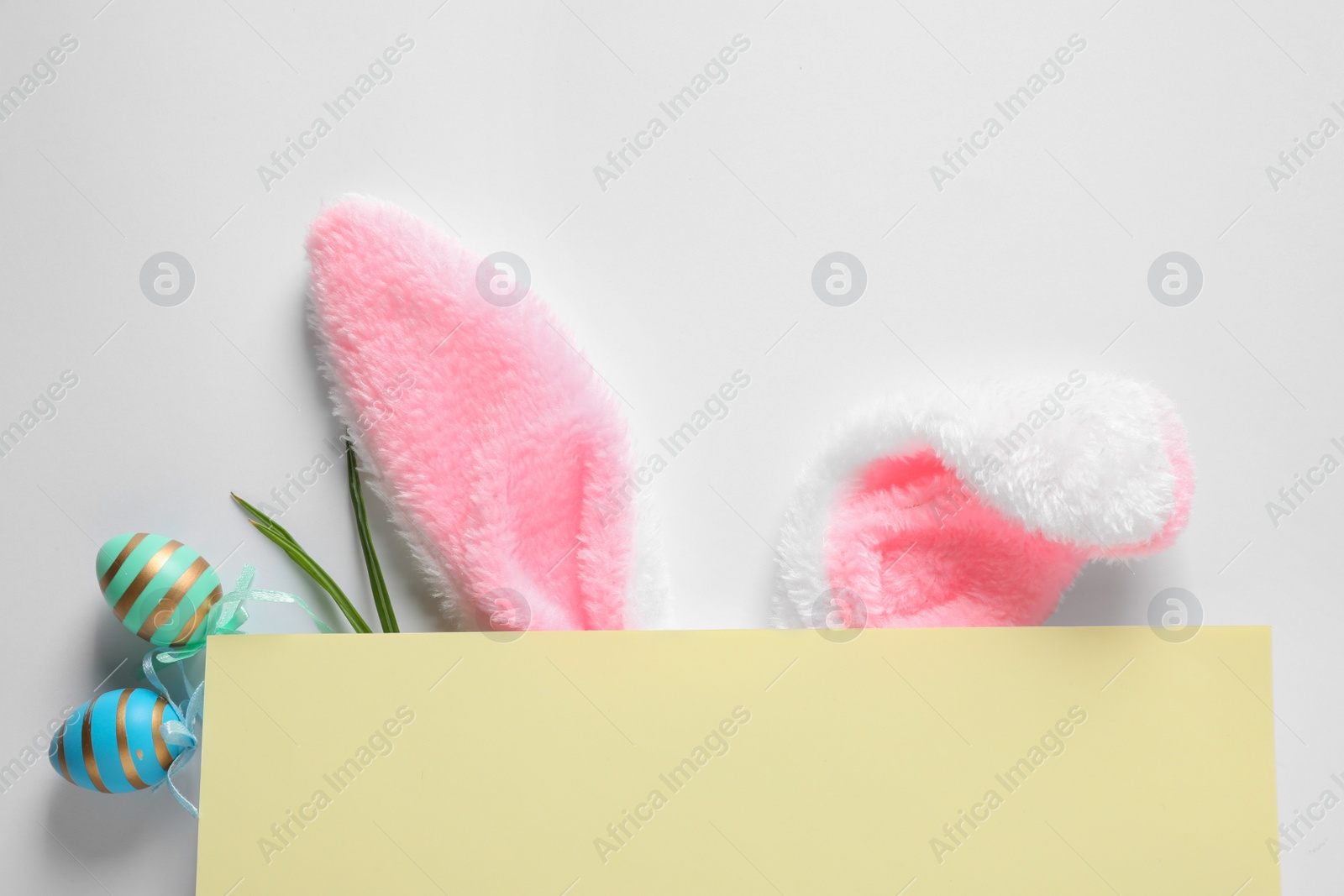 Photo of Composition with decorative bunny ears on white background, top view. Easter holiday