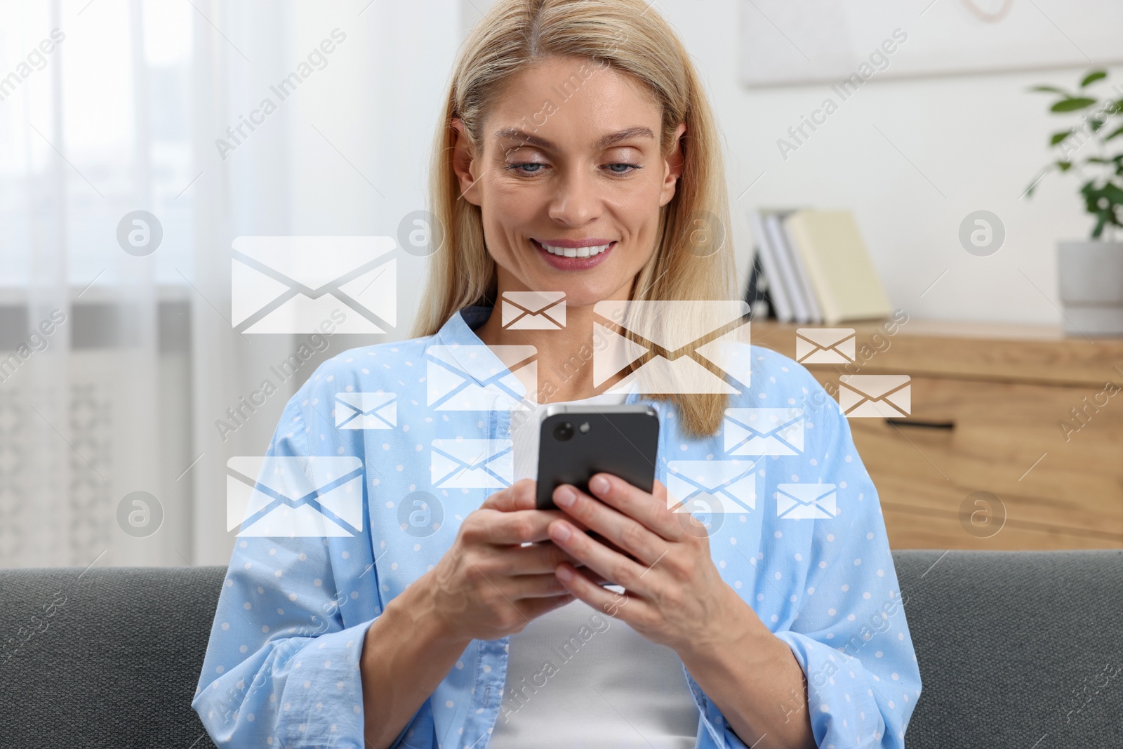 Image of Smiling woman with smartphone chatting indoors. Many illustrations of envelope as incoming messages around device