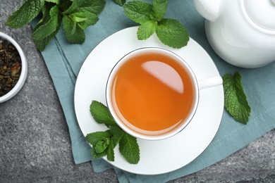 Photo of Cup of hot aromatic mint tea on grey table, flat lay