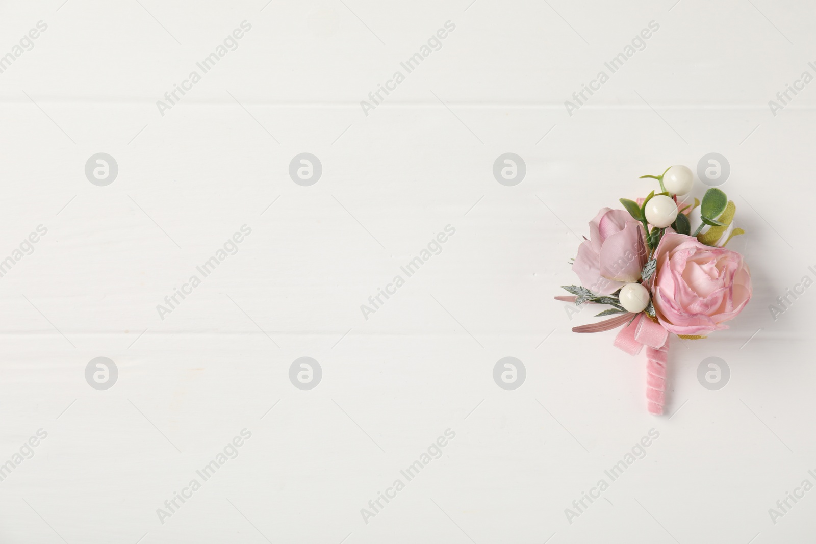 Photo of Beautiful boutonniere on white background, top view. Space for text