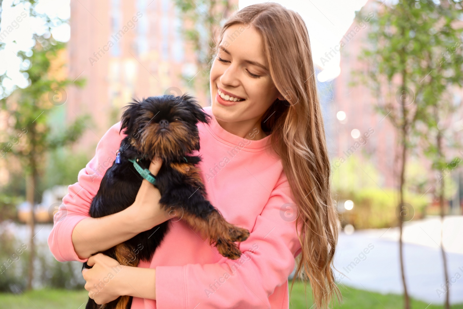 Photo of Young woman with adorable Brussels Griffon dog outdoors