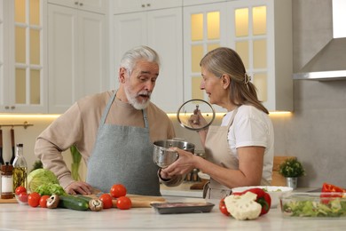 Lovely senior couple cooking together in kitchen