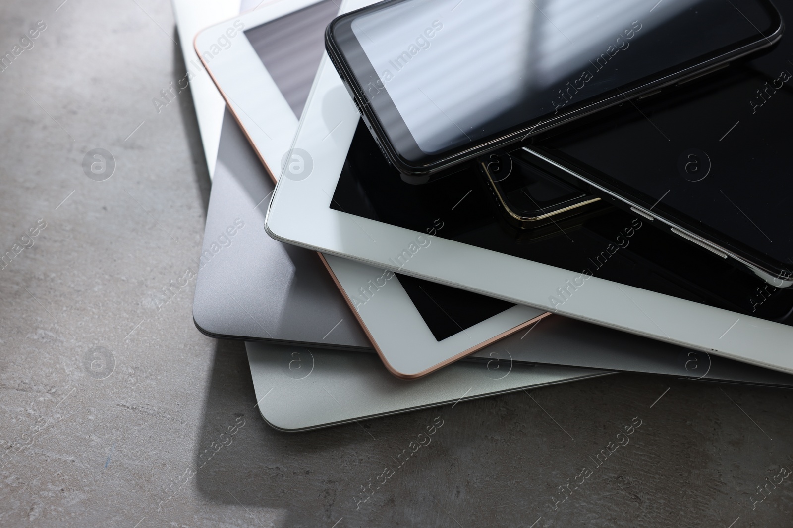 Photo of Many different modern gadgets on grey table, closeup