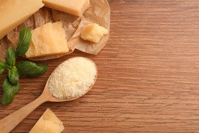 Photo of Delicious parmesan cheese on wooden table, flat lay. Space for text