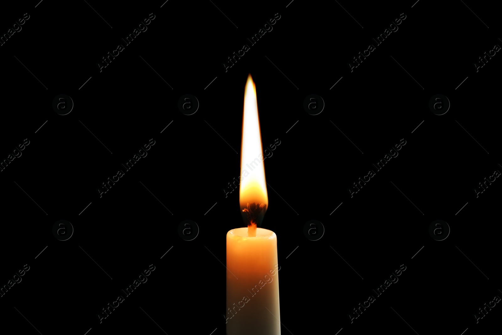 Photo of Wax candle burning on black background