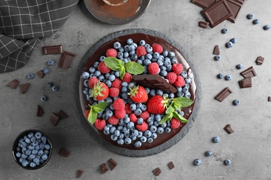 Flat lay composition with freshly made delicious chocolate cake on grey table