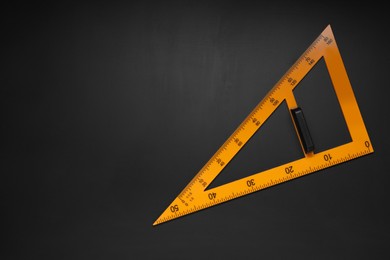 Photo of Yellow school triangle on blackboard, top view
