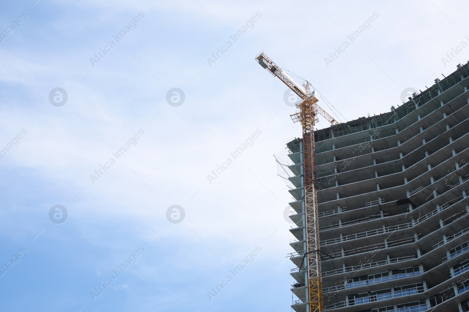 Photo of Construction site with tower crane near unfinished building