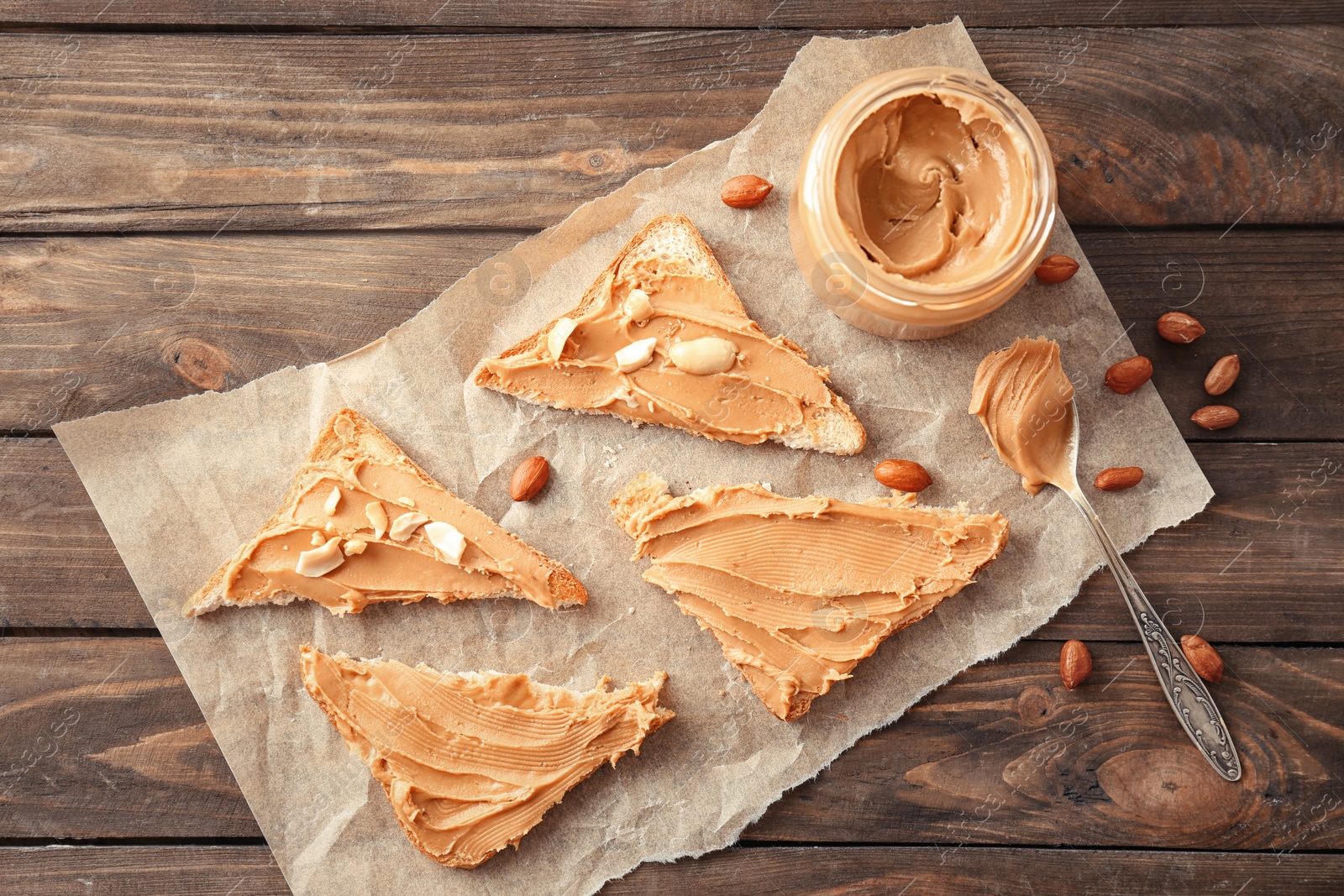 Photo of Tasty toasts with peanut butter and jar on table